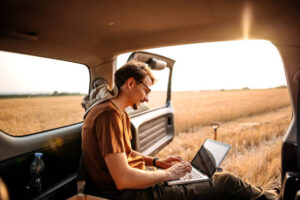 Young farmer collecting data of his field on laptop - Rent 4x4 Car Uganda how to rent a 4x4 car in Uganda